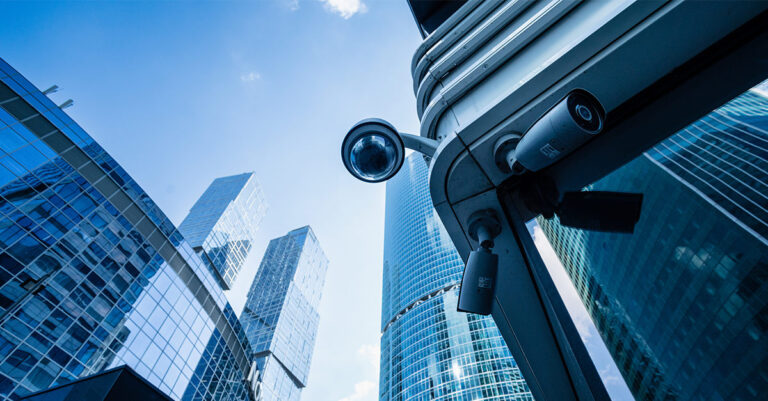 Security camera on a business building corner with modern skyscrapers in the background